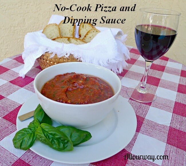 All Our Way no-cook pizza and dipping sauce in a white bowl on a table with a bread basket of sliced bread and a glass of red wine on the side. @allourway.com