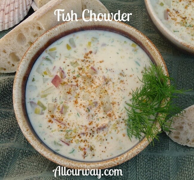 Sheepshead Fish Chowder in a brown bowl with green dill garnishing the side and slices of baguette bread on the side of the bowl. 