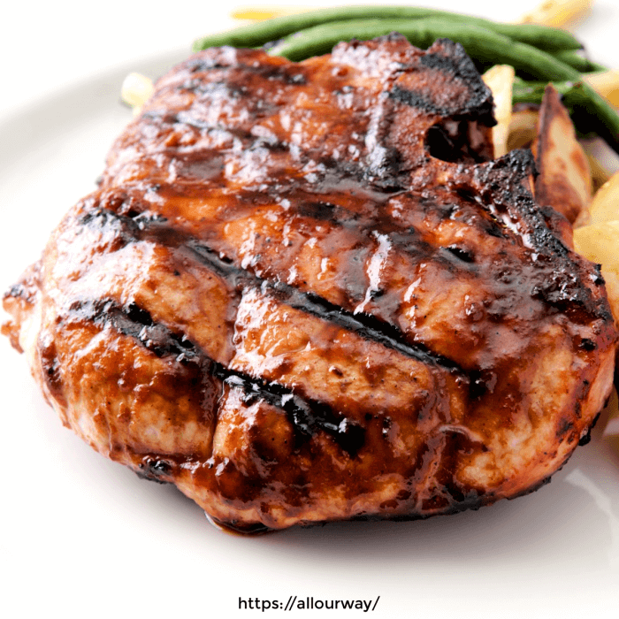 Grilled Pork Loin Chop in White plate with green bean on the side