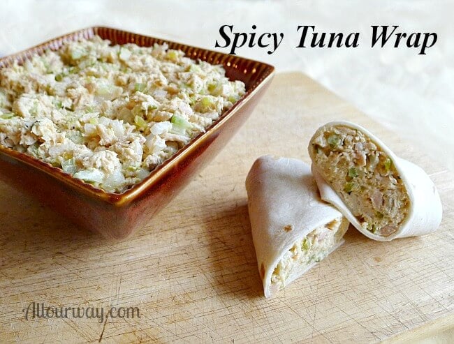 Tuna salad in a square brown bowl with a sliced tuna warp on the side on top of a cutting board. 