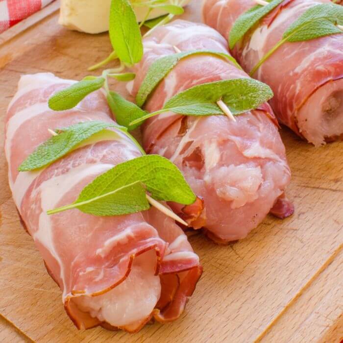 Chicken Saltimbocca rolls ready to fry in skillet. 