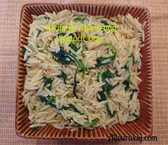 Lemon and spinach orzo pasta recipe resembles risotto in a square brown dish on top of a brown and orange dishtowel. @Allourway.com