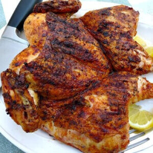 Butterflied chicken, grilled, basted with lemon butter sauce, resting.