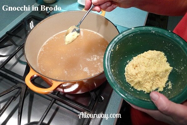 Putting the gnocchi in the rich broth for gnocchi in brodo.