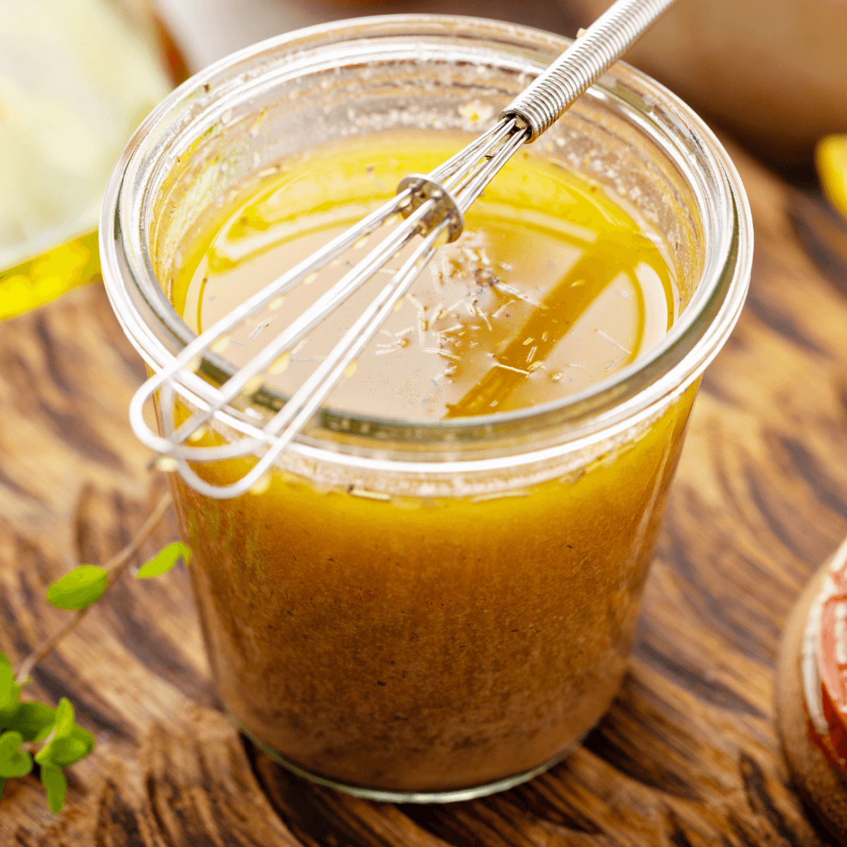 A jar filled with Lemon Butter Sauce Recipe with a whisk