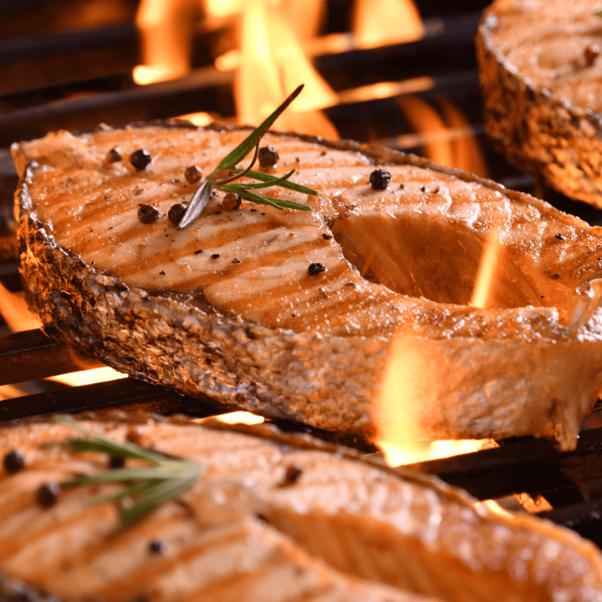 Grilled salmon on the grill basted with lemon butter sauce. 