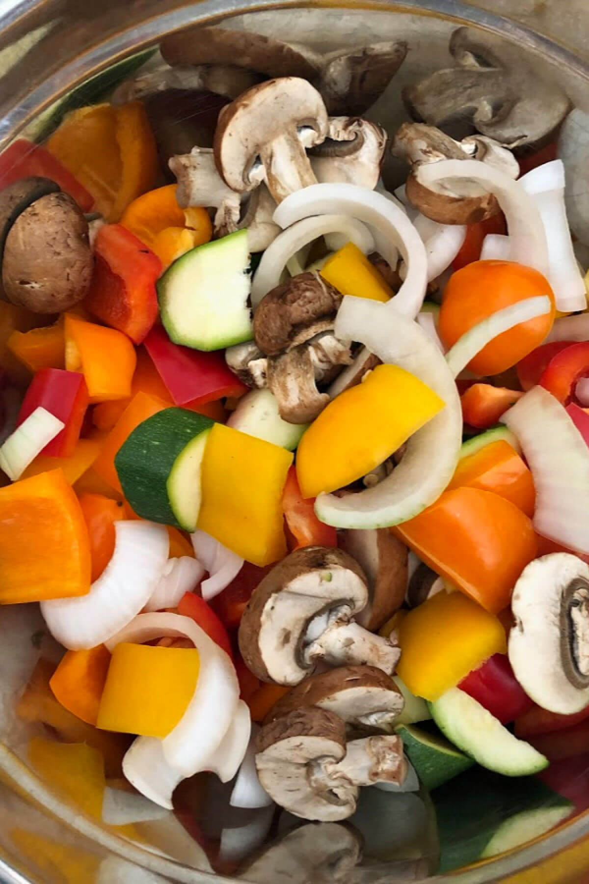 A mixing bowl filled with cut vegetables in preparation for making the grilled vegetables. 