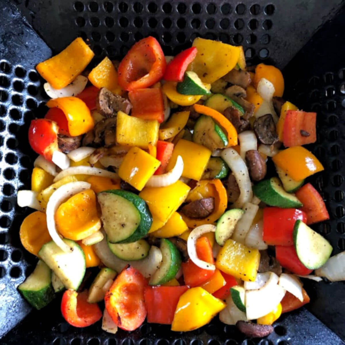 Grilled peppers, mushrooms and onions in a grill wok.