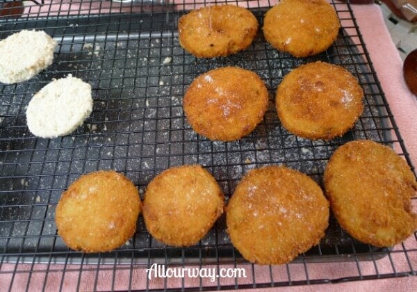 Crunchy fried green tomatoes , salted and on a black wire cooling rack.