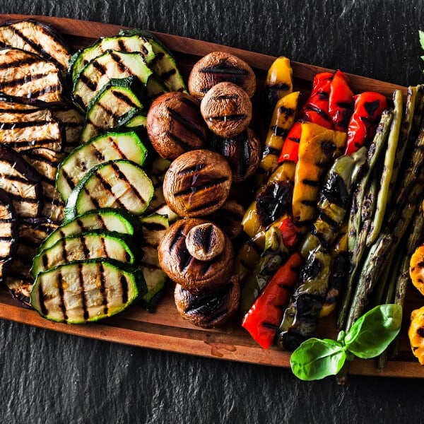 A platter of grilled vegetable slices, zucchini, mushrooms, peppers, asparagus, eggplant. 