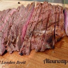 London Broil Marinated with Dijon mustard than grilled and sliced cross grain on wood cutting board.