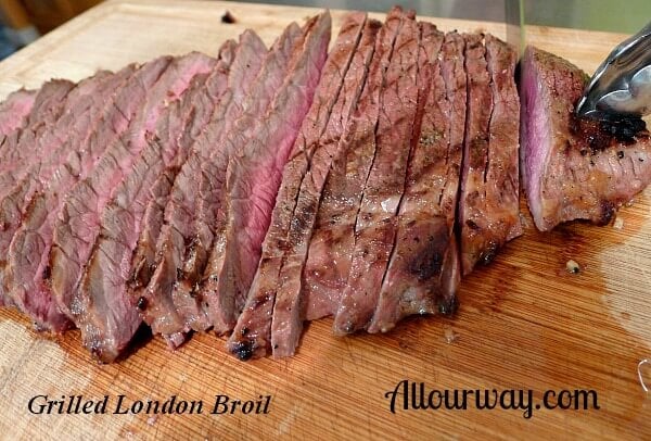 London Broil Marinated with Dijon mustard than grilled and sliced cross grain on wood cutting board.