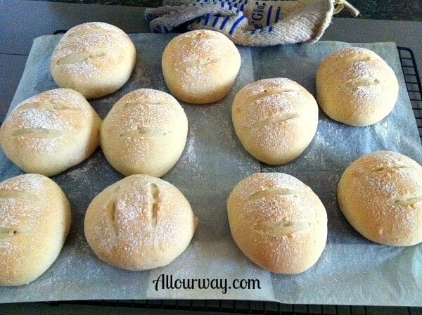 Potato Sourdough Buns on a parchment lined black cooling rack. 