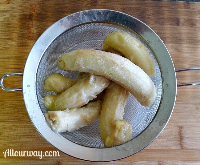 Frozen Bananas in wire sieve over bowl catching the water from the bananas for Chocolate Chip Muffins - bananas thawing in strainer @Allourway.com