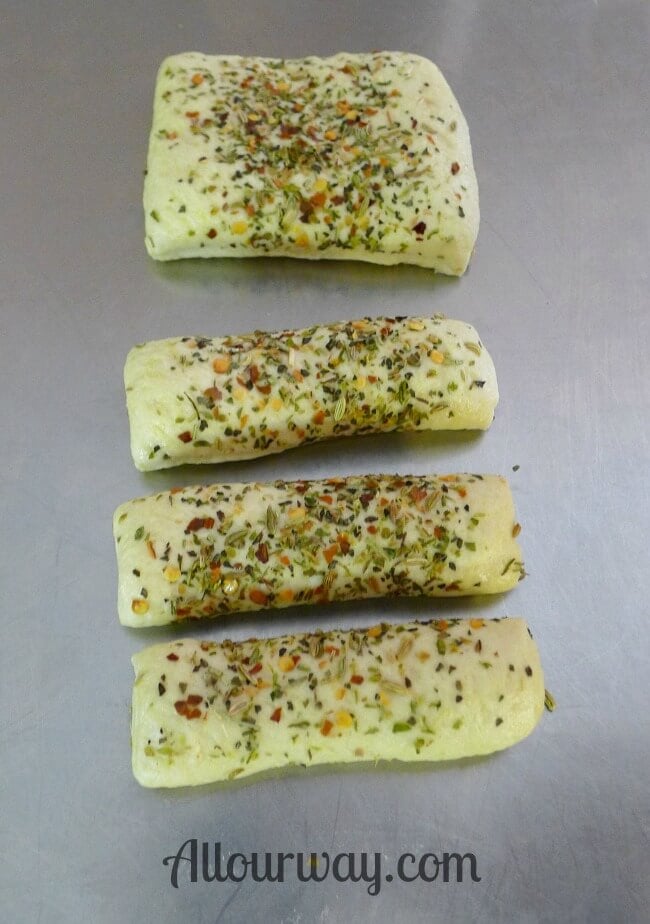 Grissini breadsticks dough sprinkled with the Italian seasonings.