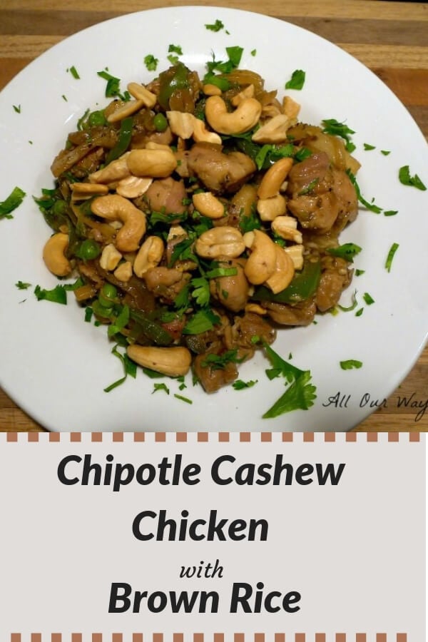 Close up of Chipotle cashew chicken in a large white bowl with cilantro sprinkled on top. 