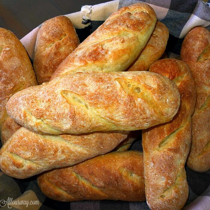 Close up of the Italian Rolls all nice and golden in a brown and black napkin lined bread basket. 