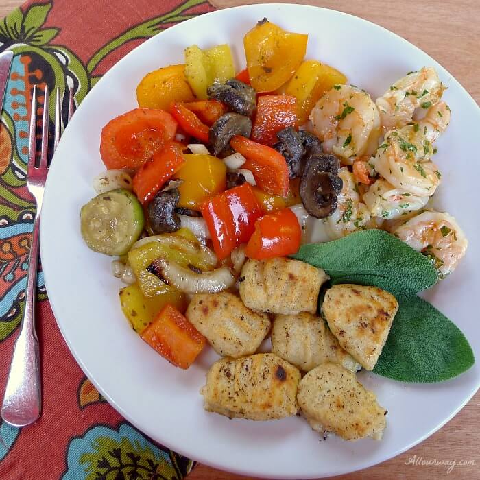 Ricotta Gnocchi with grilled shrimp and peppers on a white plate with a rust and green multi colored napkin@allourway.com