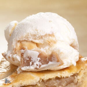 A scoop of Caramel Apple Pie No Churn ice cream on top of a slice of apple pie.