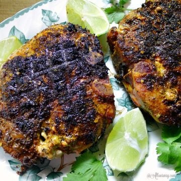 Grilled Lime Adobo Rubbed Pork Chops have the flavor of Mexico with lime on green leaf platter