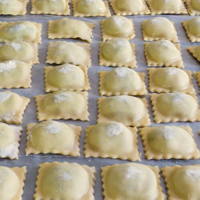 Row after row of Spinach Ricotta Beef Ravioli Filling lined up on cookie sheet ready to freeze.i