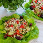 Mediterranean Grain Salad with Gorgonzola served on a bed of Boston green lettuce features grape tomatoes, kalamata olives, and the grain is farro.