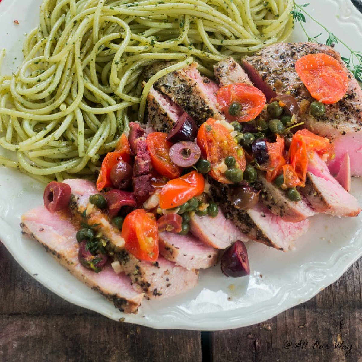 Southern Italian Grilled Tuna Steaks with a fresh grape tomato and black olive sauce to top the delicious sliced medium rare tuna along with green pesto pasta.