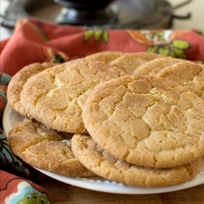 Brown Butter Snickerdoodle Cookies on a white plate with a burnt orange napkin on the side. 