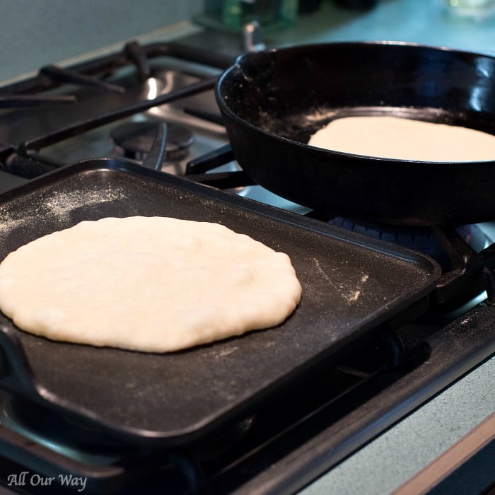 Cooking the Flatbread on two black cast iron pans. 