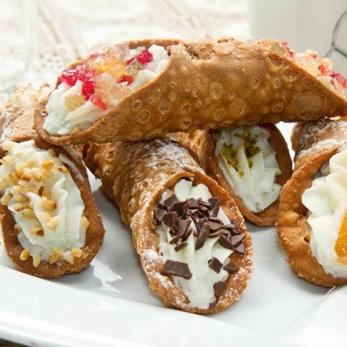 Cannoli Cake with chocolate-dipped strawberries is a variation of the Sicilian pastry. 