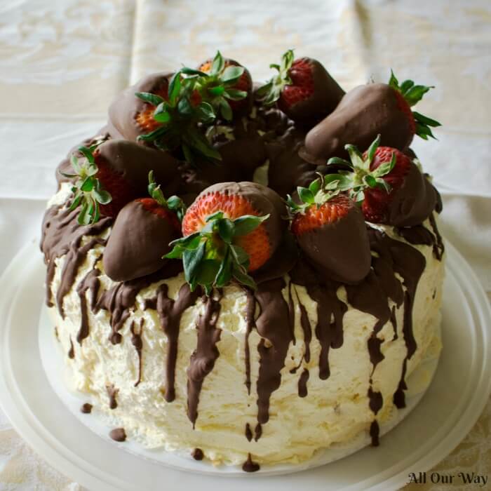 Cannoli cake with whipped cream frosting and chocolate dipped strawberries is variation of the Sicilian classic. 