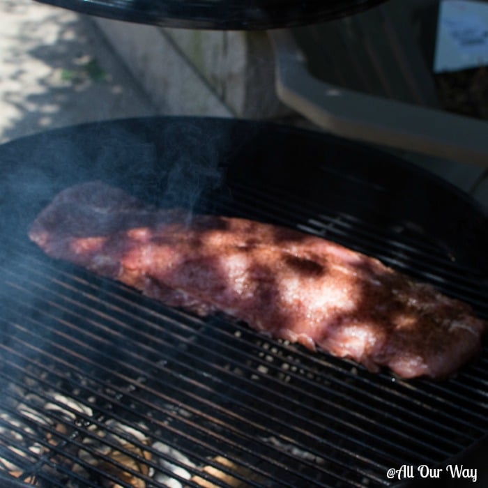 Asian barbecued ribs are smoking on the grill. They can be grilled or baked