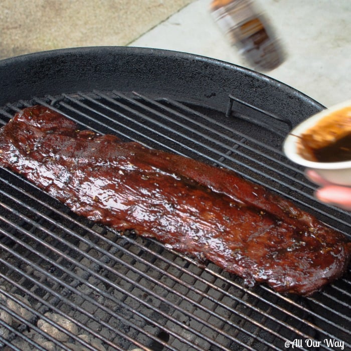 Asian barbecued ribs being basted with a sweet, salty, spicy, sticky sauce. 