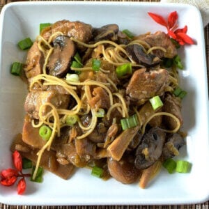 Chinese Chop Suey recipe and American version on a white plate with red blossoms on the edge.