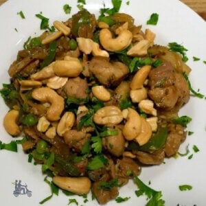 Chipotle Chicken with cashews sprinkled with cilantro on top of chicken and rice.