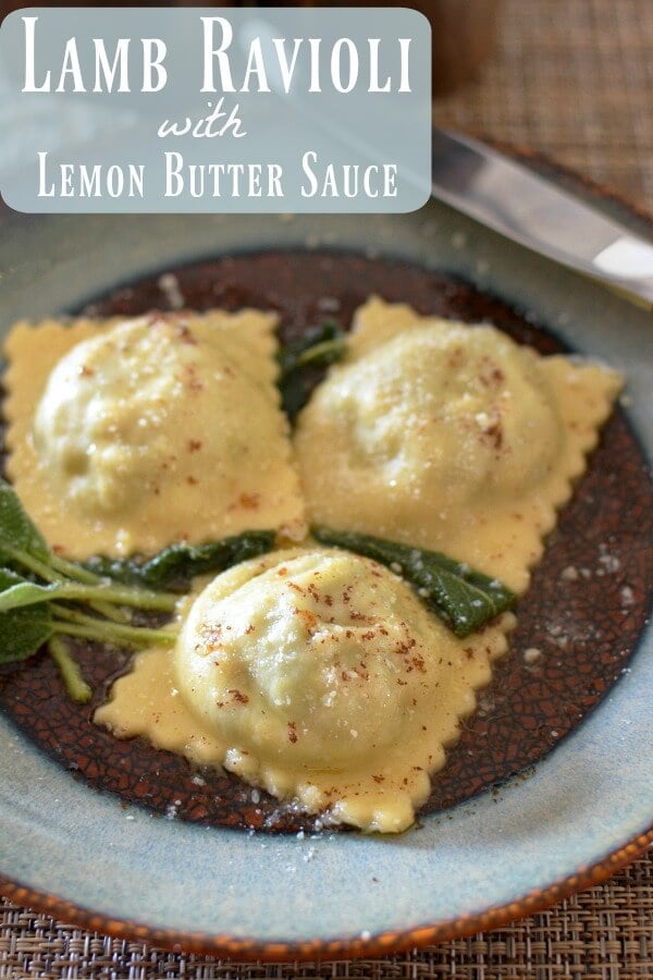 Close up of 3 Lamb ravioli and green sage on a brown and blue plate sprinkled .