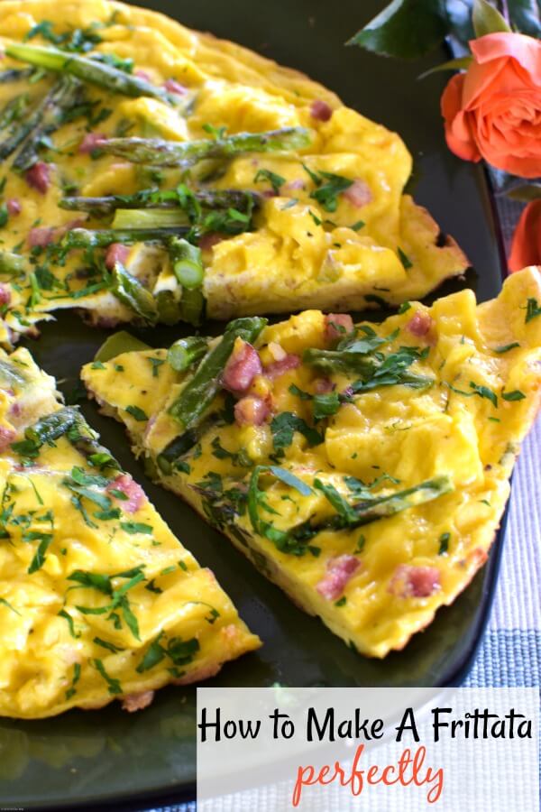 Close up of an asparagus frittata on a green plate with a slice cut. Coral roses on the right side. 