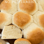 Golden brown dinner rolls on wooden cutting board