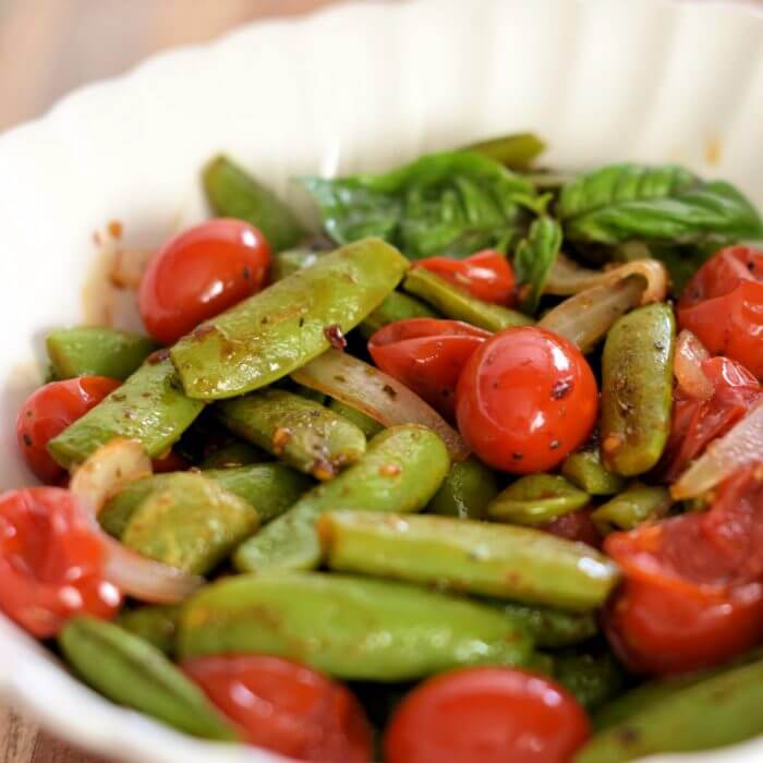 Roasted Sugar Snap Peas with Grape Tomatoes in a white bowl. 