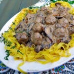 White platter filled with egg noodles topped with Italian meatballs in a creamy mushroom gravy.