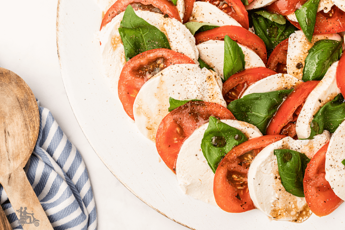 Close up of the Insalata Caprese featuring alternating slices of Tomato, mozzarella, and basil. 