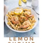 A simple lemon shrimp dinner served on a white plate with lemon wedges on the side.
