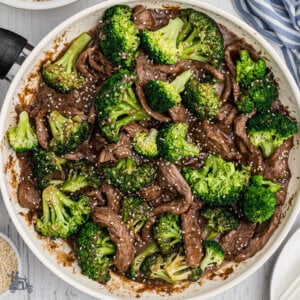A skillet filled with broccoli florets and beef strips.