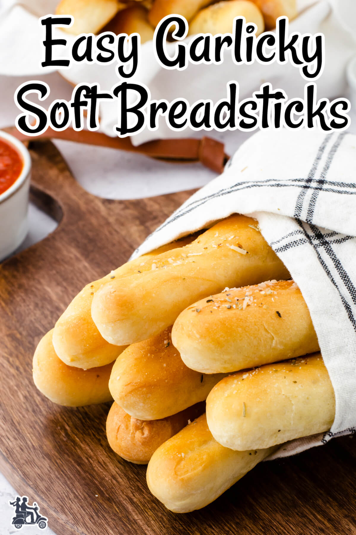 Breadsticks wrapped in white and black tea towel. 