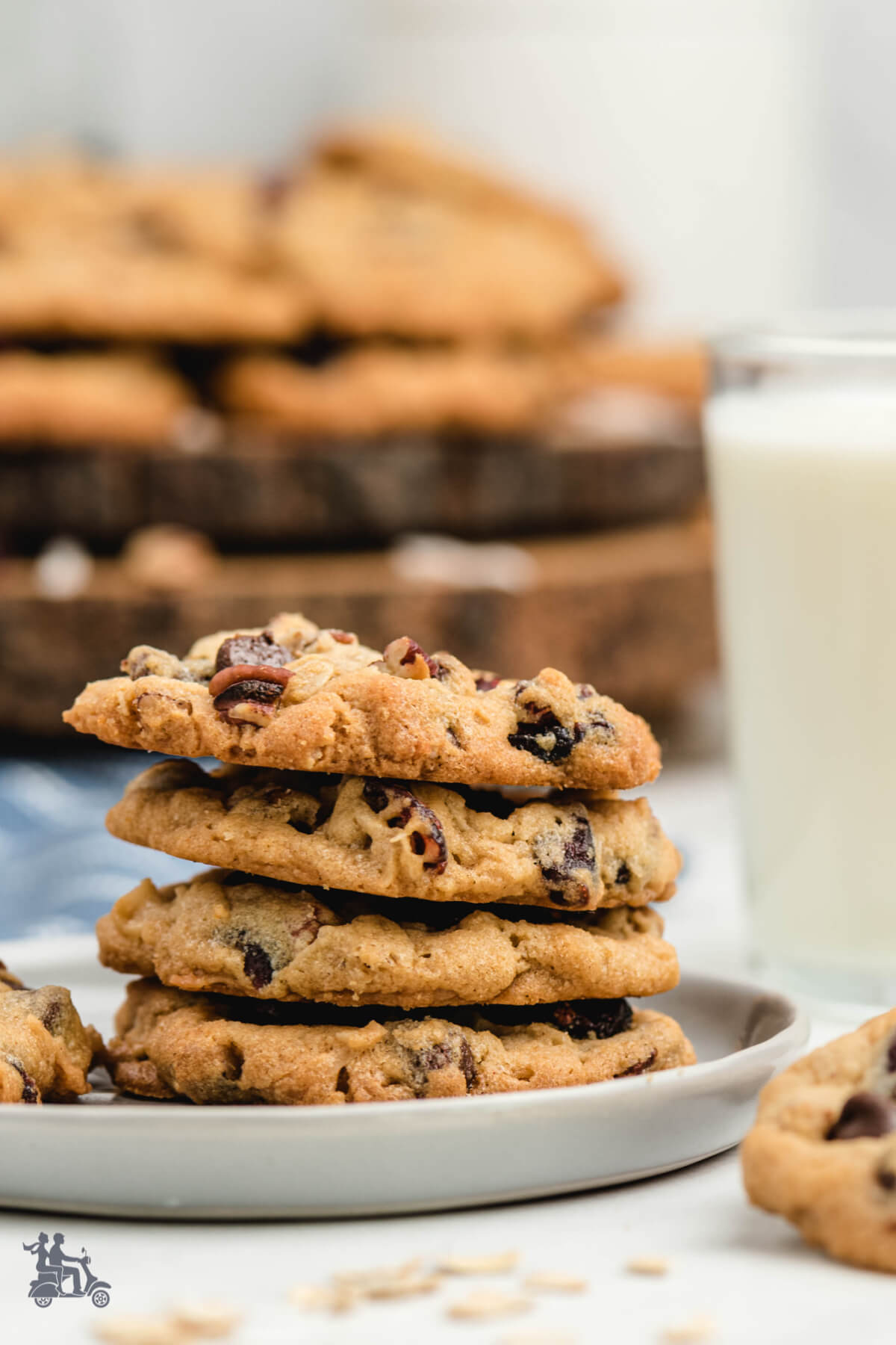 A stack of Oatmeal Cranberry Cookies with a glass of milk. 