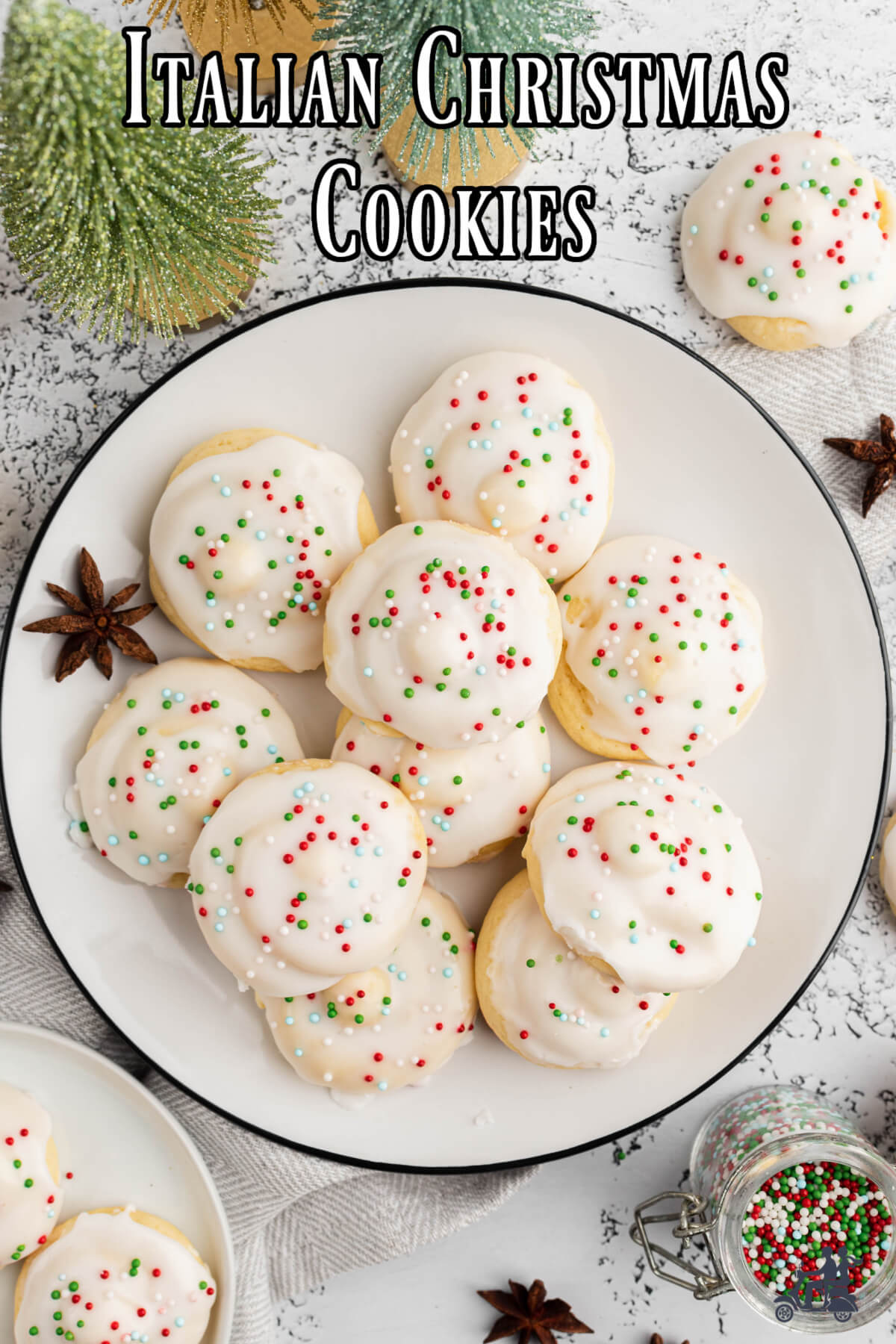 Italian Christmas cookies with a white glaze and sprinkles on a white plate.