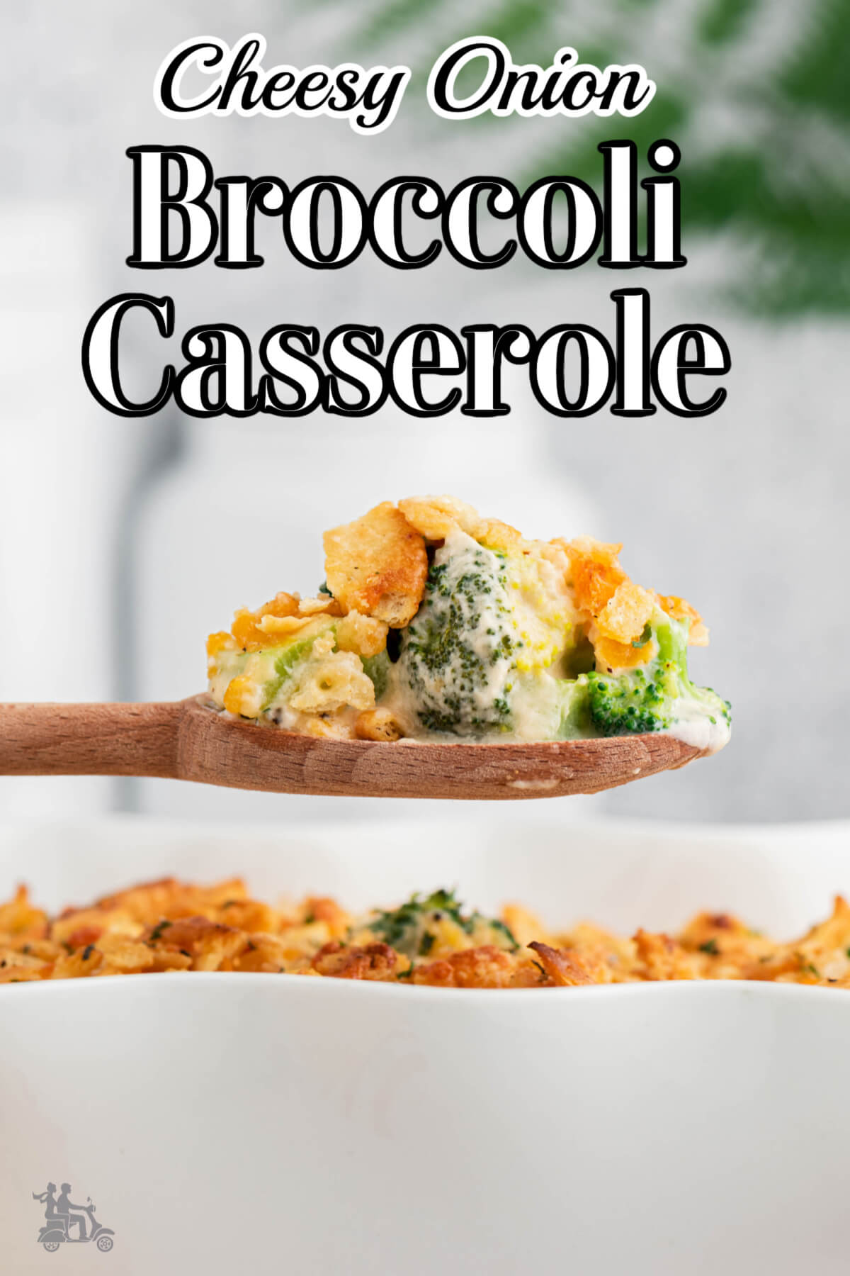 A spoonful of cheesy onion broccoli Casserole being served from a white casserole dish. 