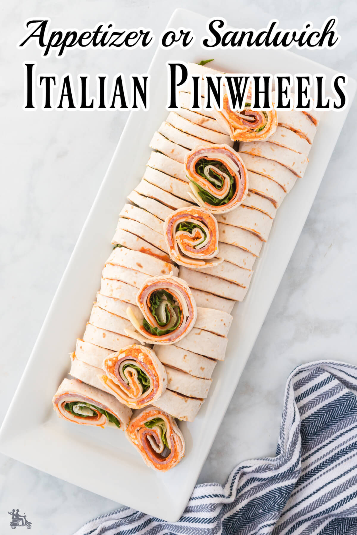 Long Italian pinwheel rolls sliced on a white platter. 
