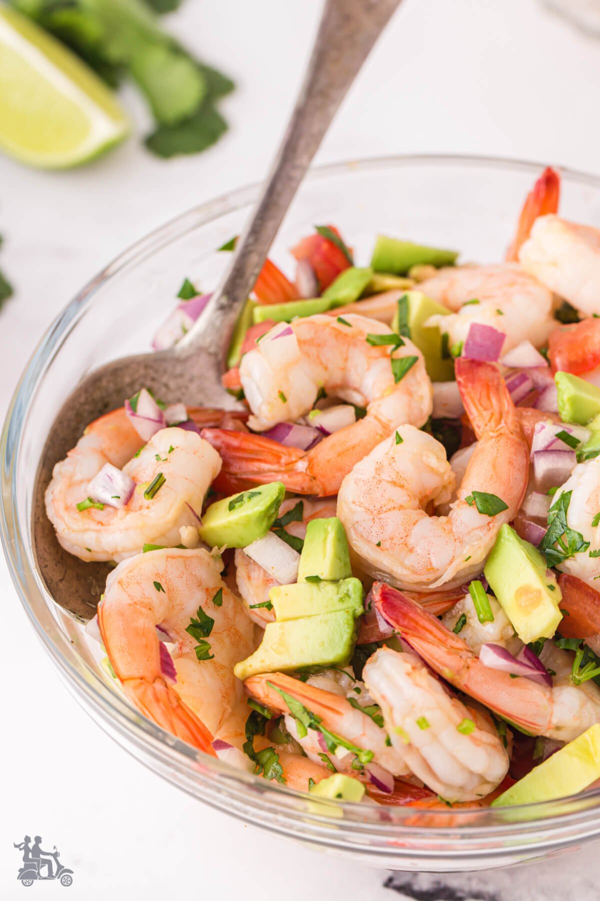 Glass bowl filled with a ceviche using shrimp as the main ingredient. 