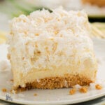 Close up of a refrigerator layered dessert made of graham cracker crust, cream cheese , pineapple and toasted coconut.